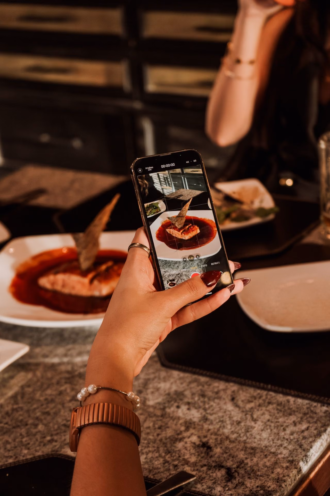 Invitada tomando foto de su platillo con el celular