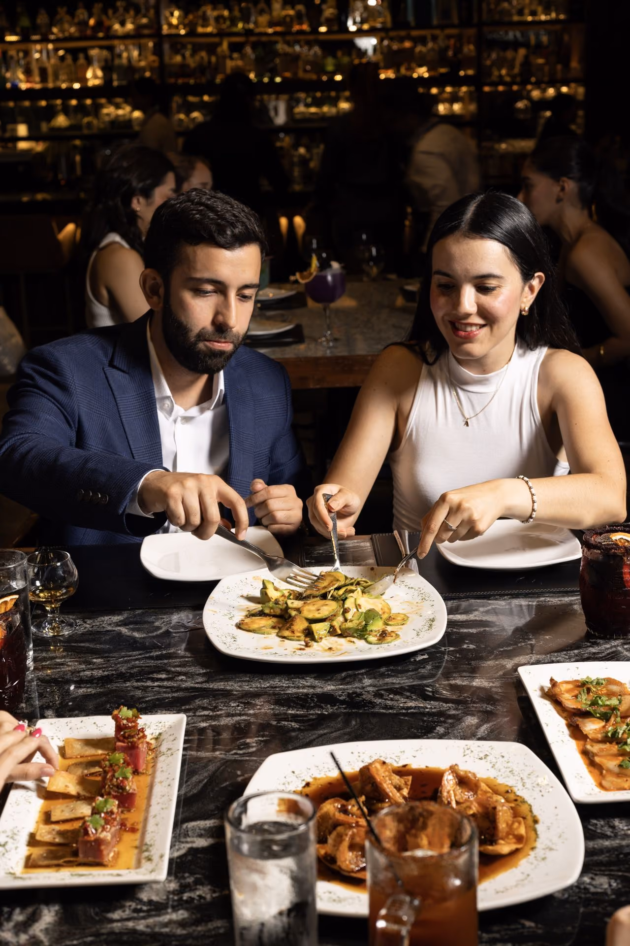 Pareja compartiendo platillos en la mesa