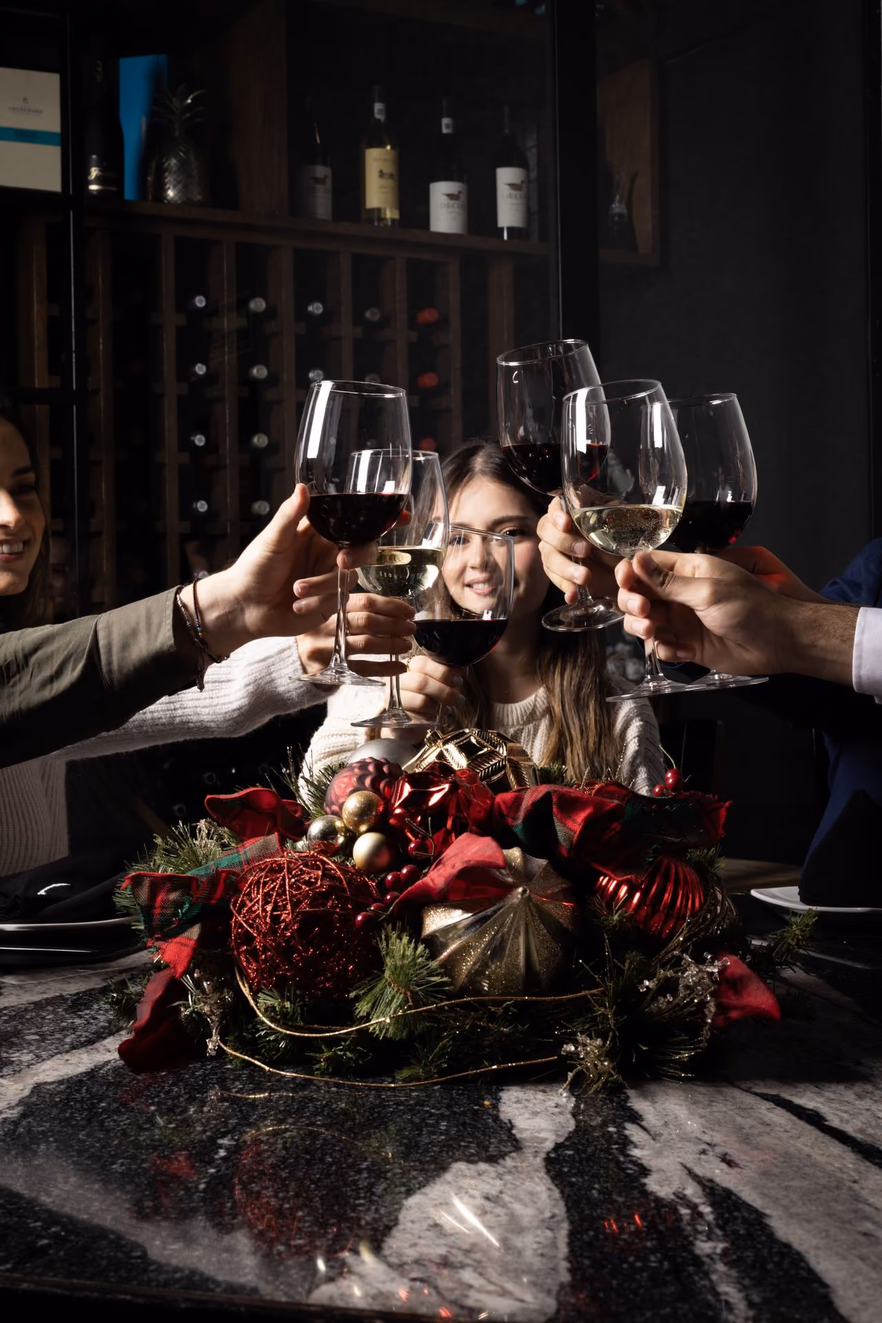 Brindis con vino sobre un centro de mesa navideño