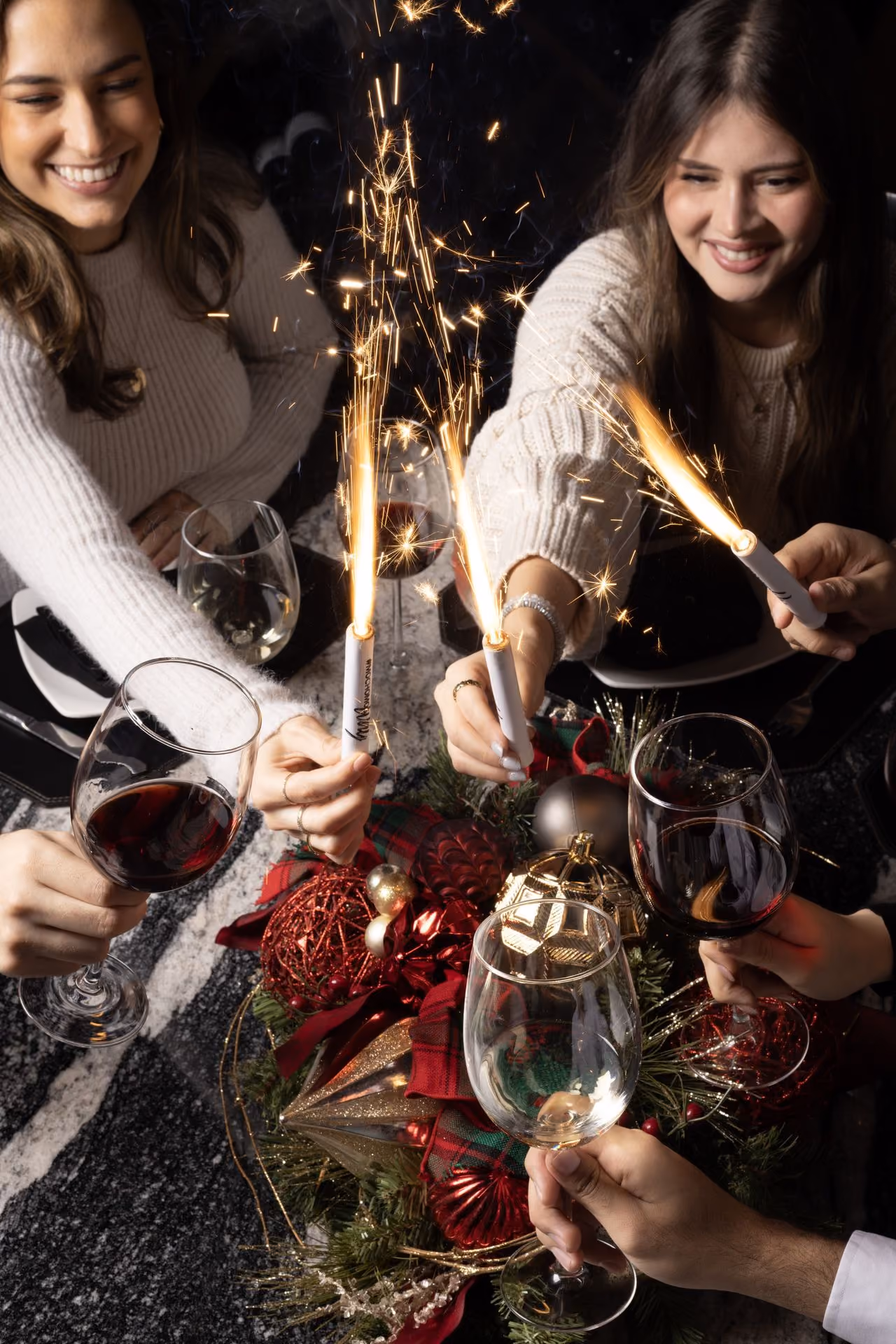 Amigas con bengalas en una mesa de fiesta