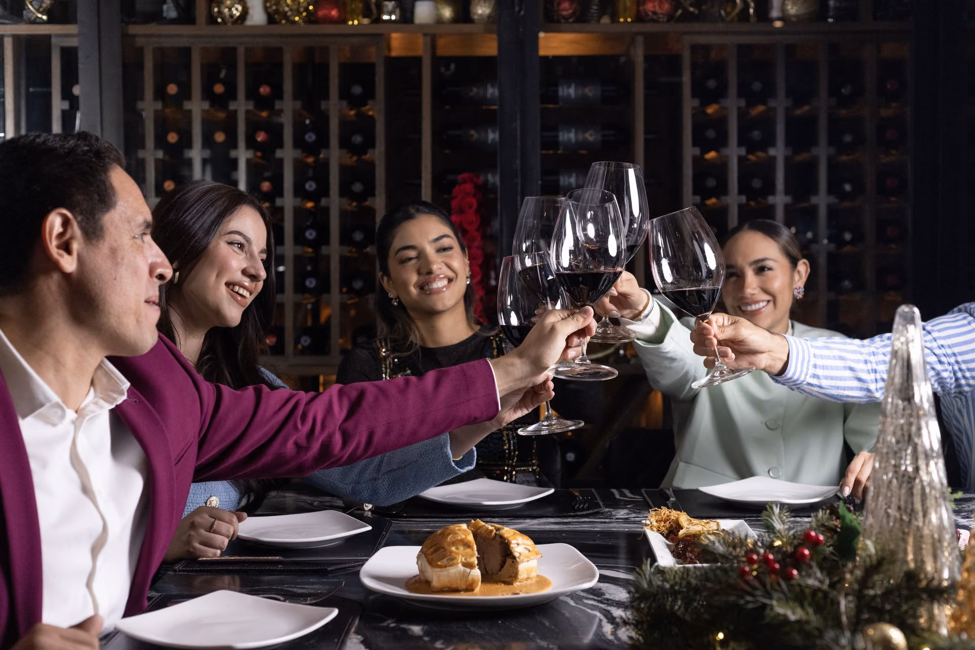 Familia brindando con vino tinto frente a la cava