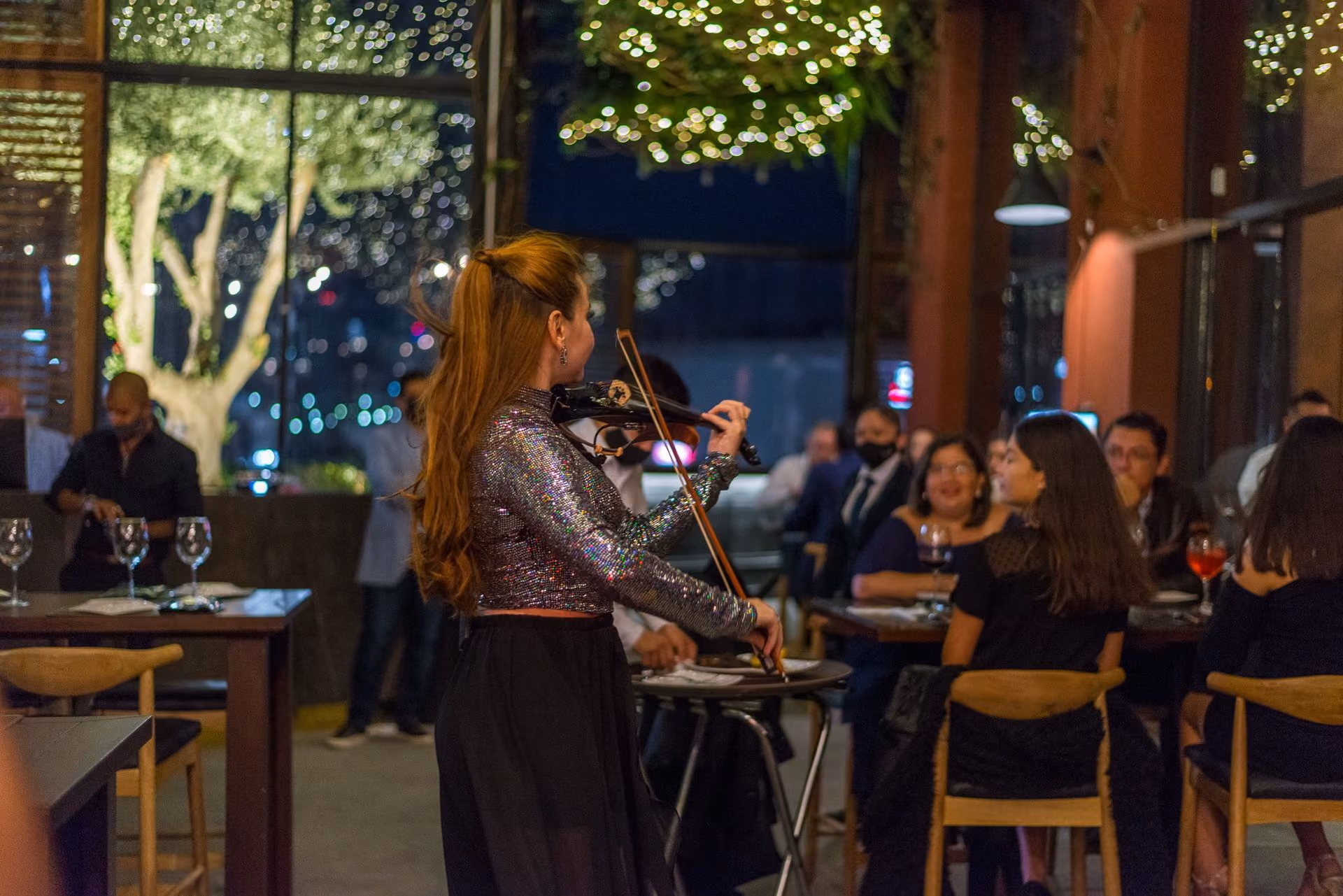 Violinista tocando entre las mesas de la terraza