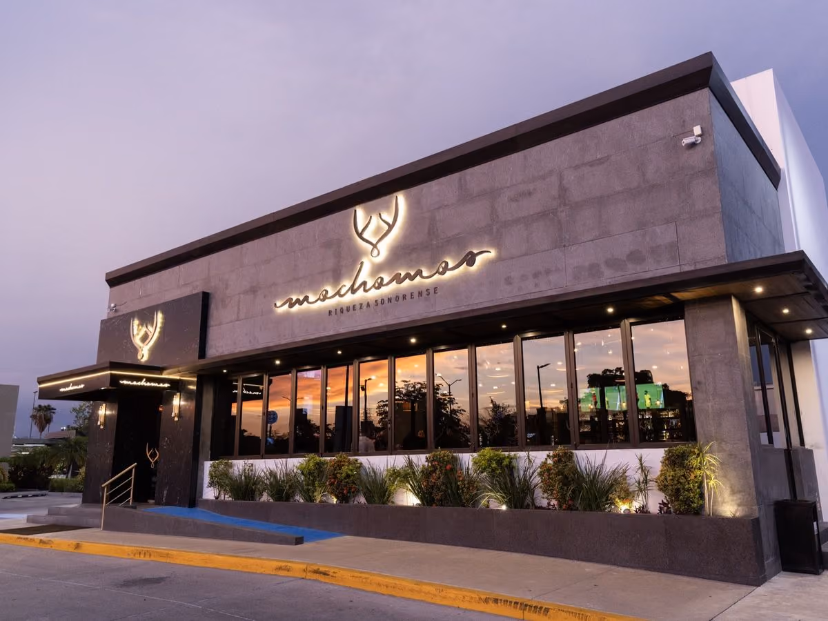 Fachada de Mochomos Culiacán con el nombre iluminado al anochecer
