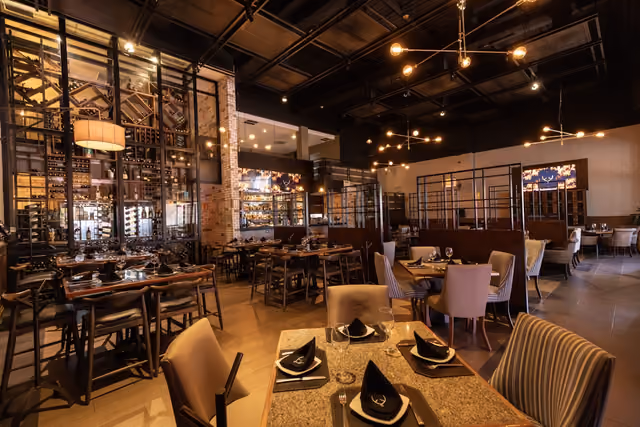 Salón de Mochomos Culiacán con candiles dorados y la barra al fondo