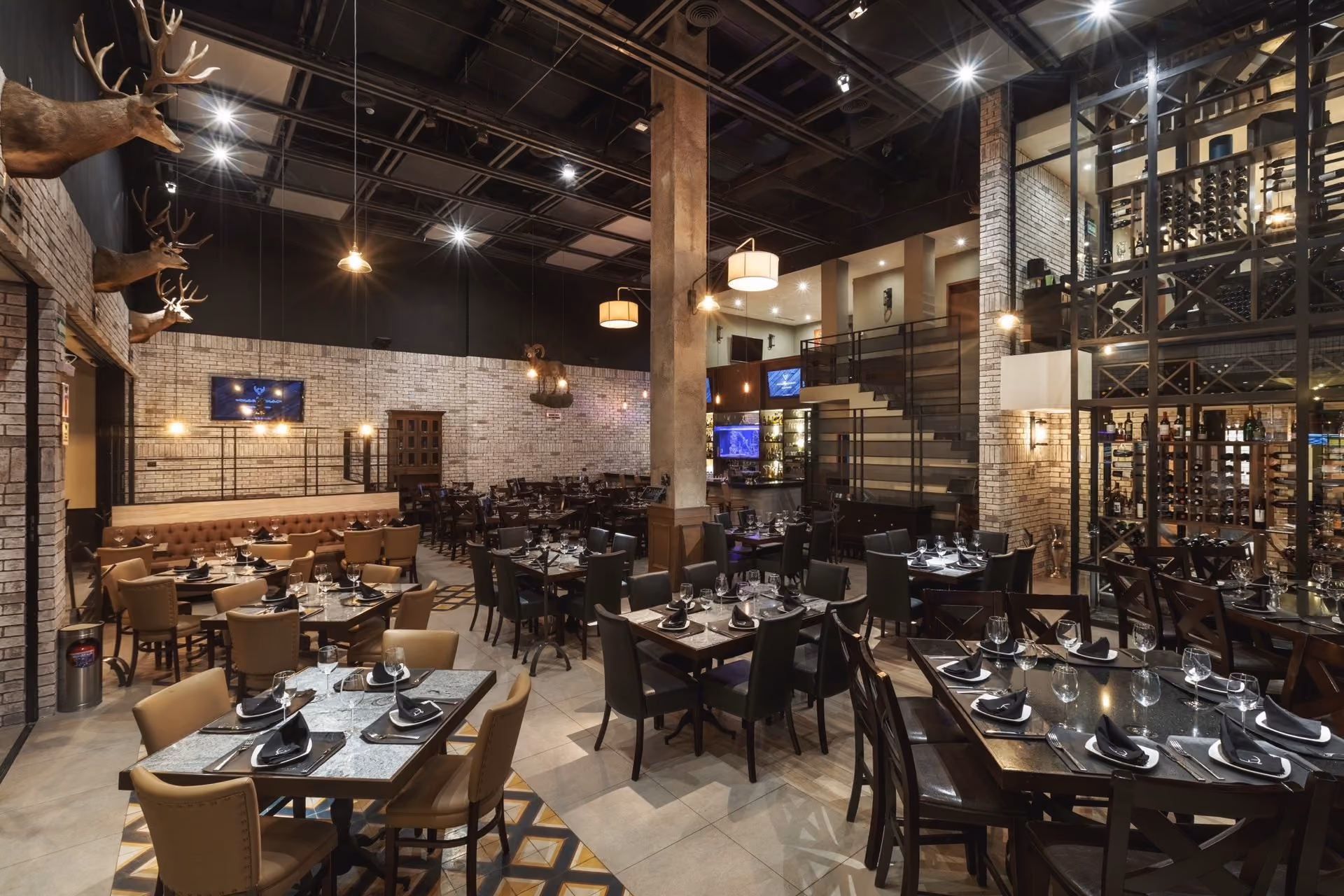 Salón principal de Mochomos Hermosillo con trofeos de venado y la cava al fondo