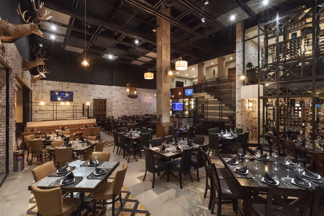 Salón principal de Mochomos Hermosillo con trofeos de venado y la cava al fondo