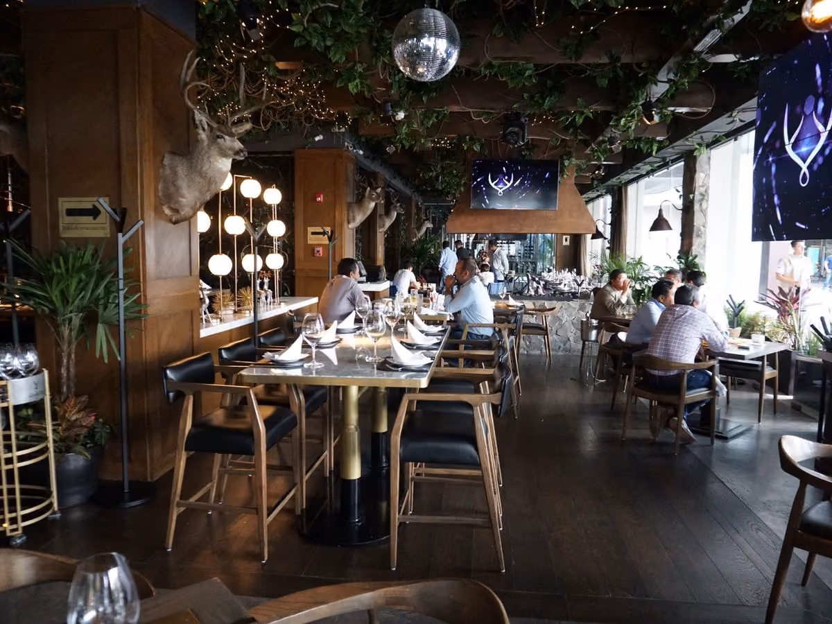 Salón de Mochomos Metepec con techo de enredadera y barra de madera