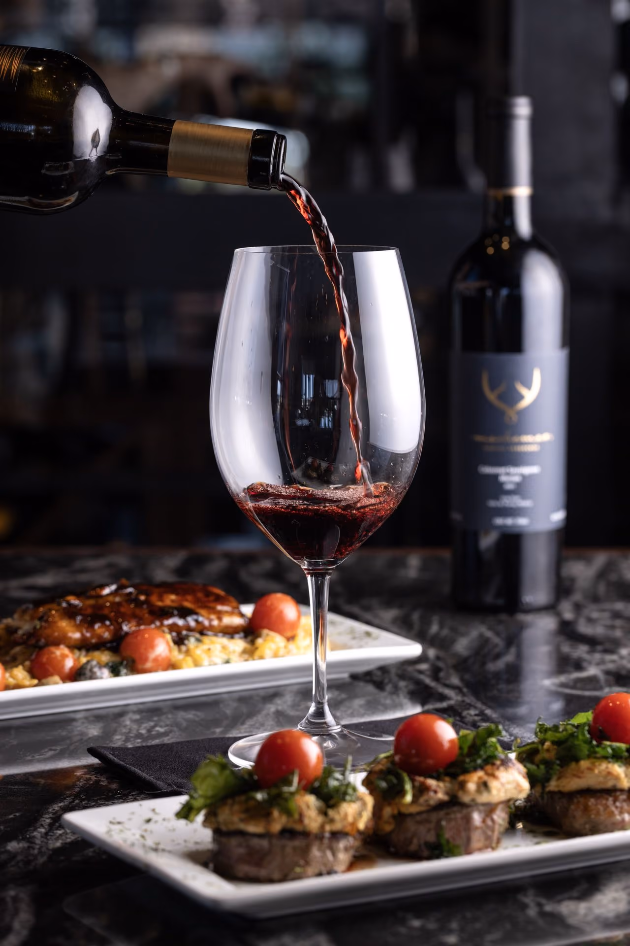 Vino tinto sirviéndose junto a una mesa de entradas