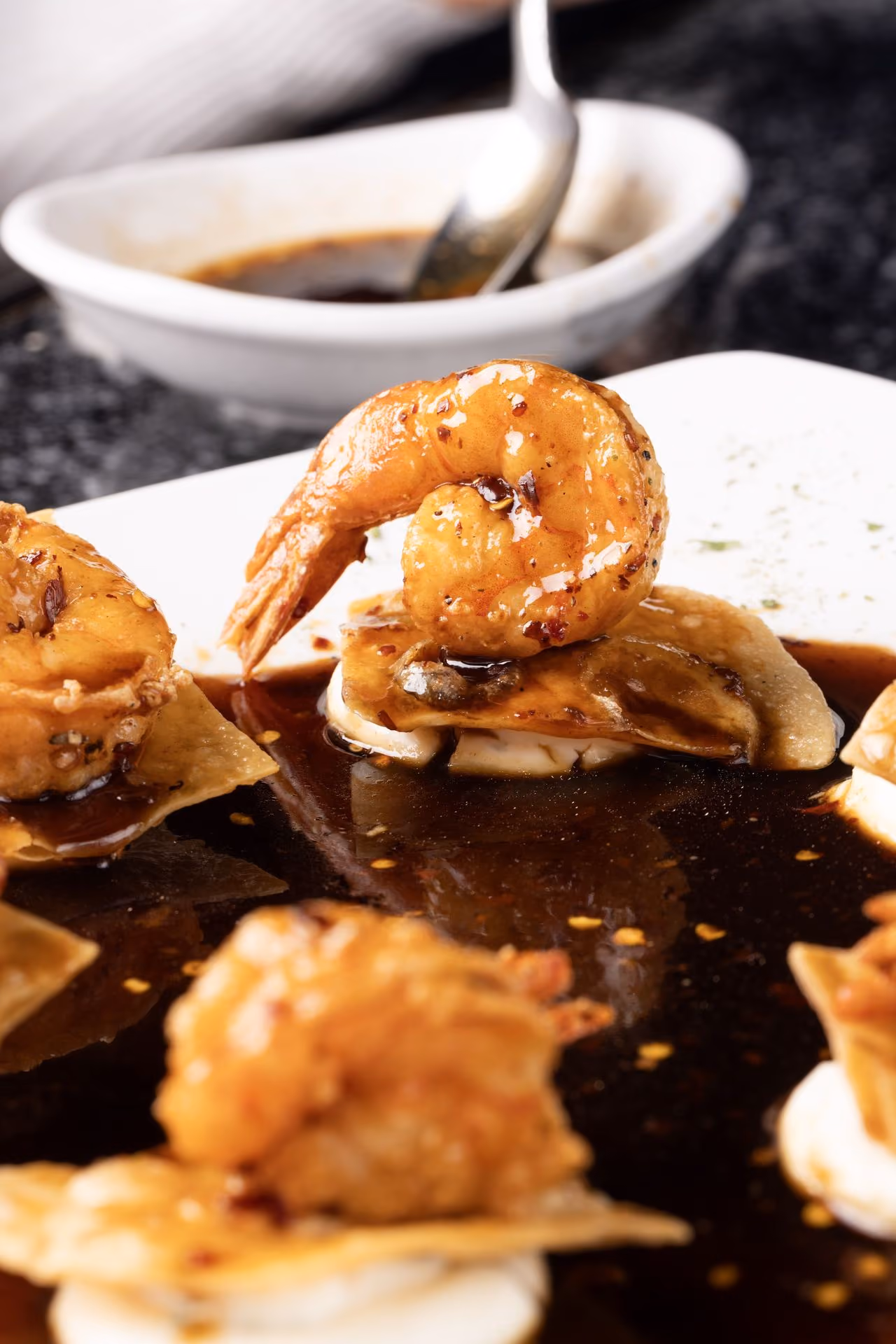 Camarones glaseados servidos con salsa oscura