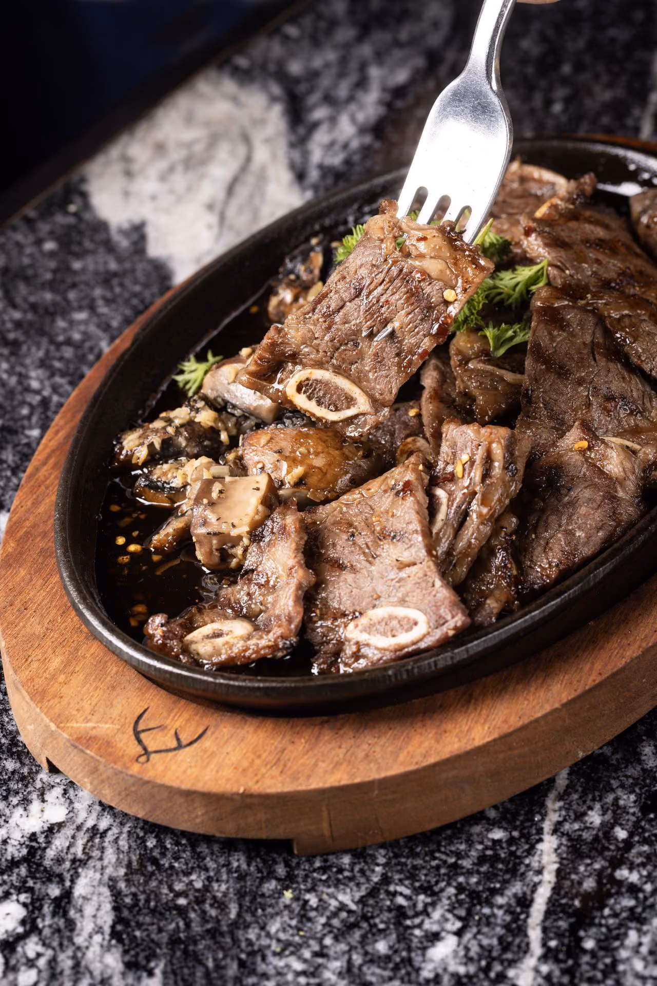 Costilla de res en rodajas sobre plato de hierro
