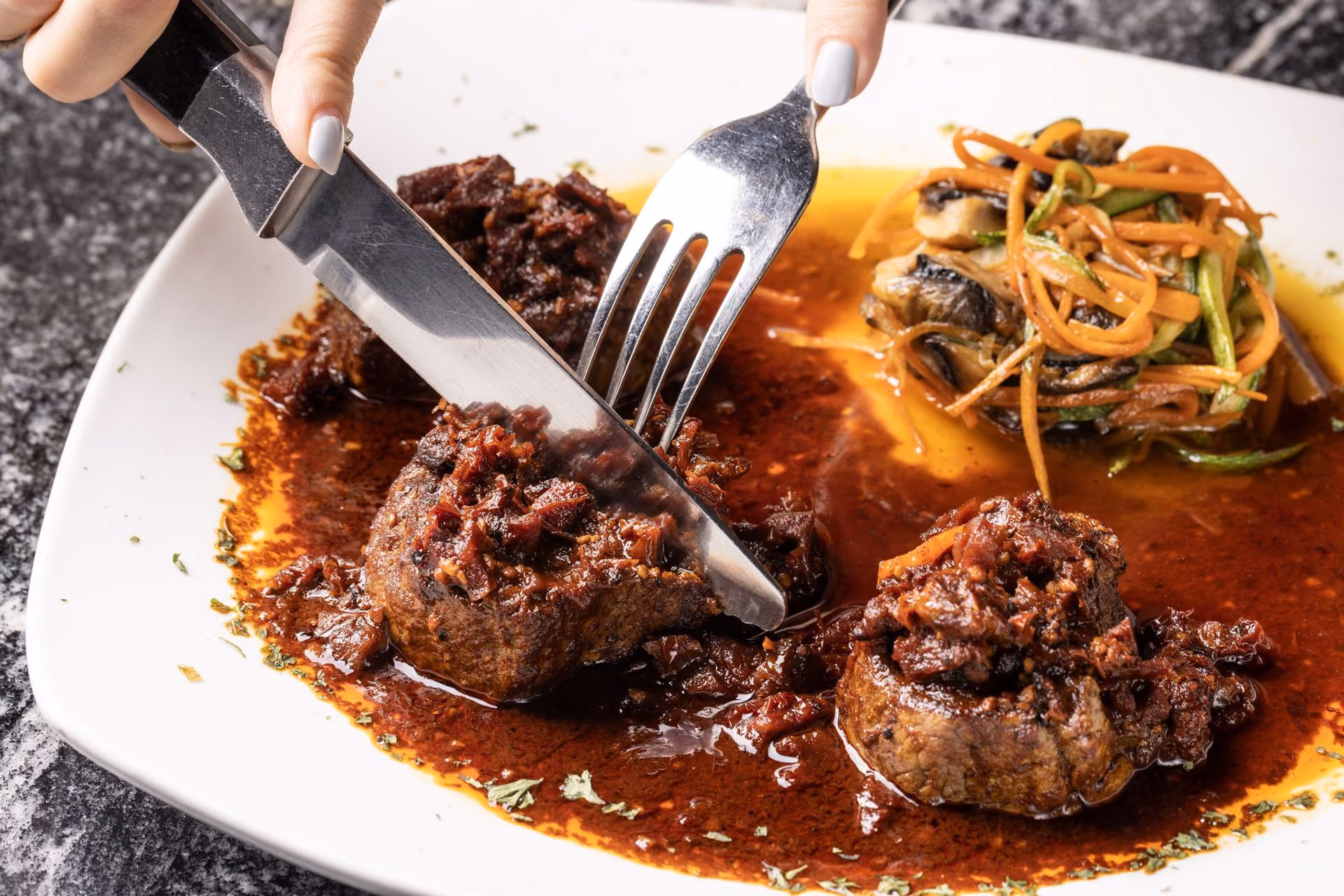 Medallones de filete en salsa, cortados en la mesa