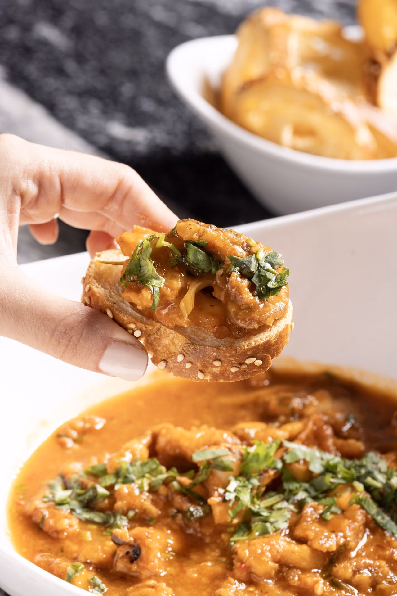 Bocado de mariscos tomado sobre un plato de guiso
