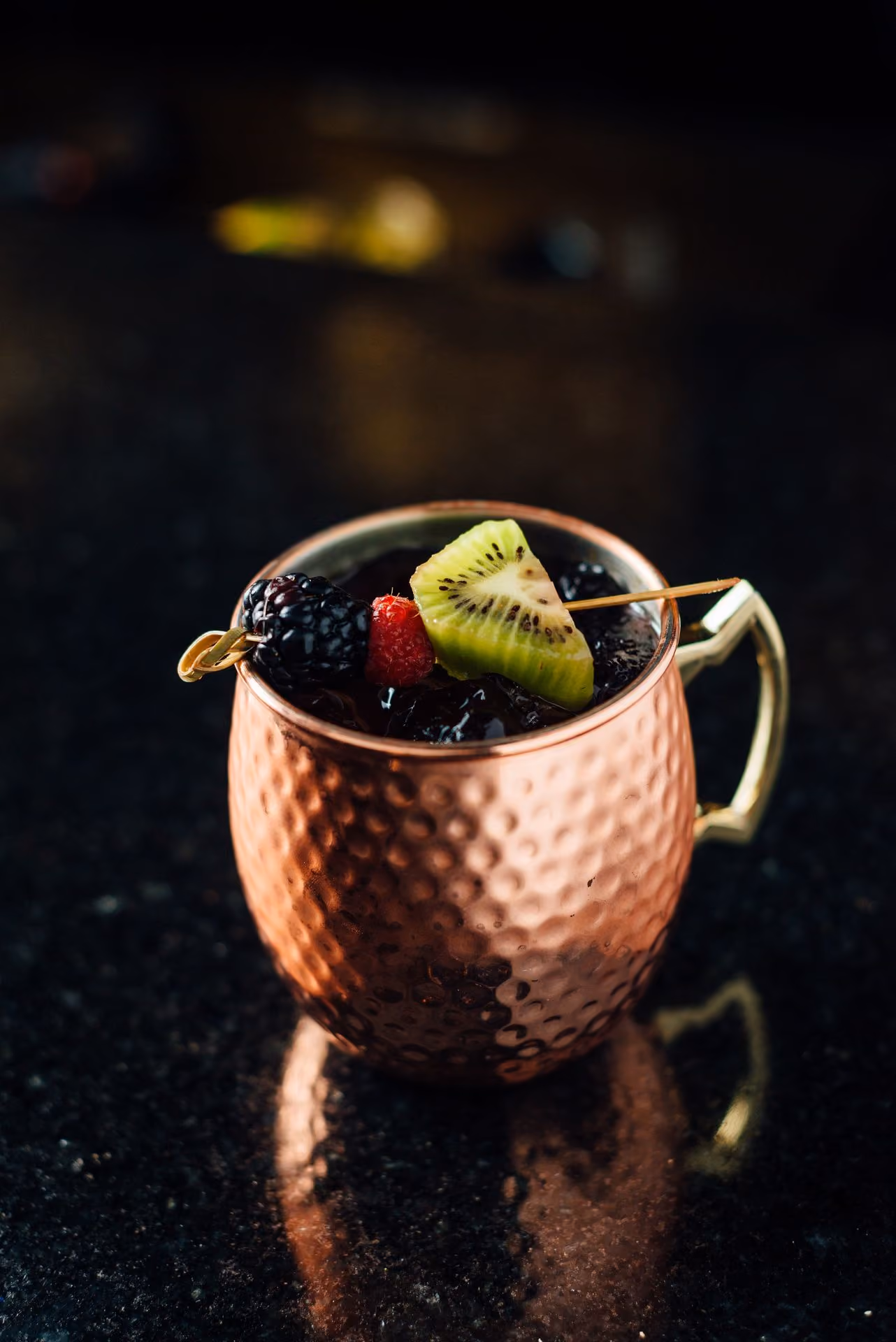 Coctel en taza de cobre con moras y kiwi