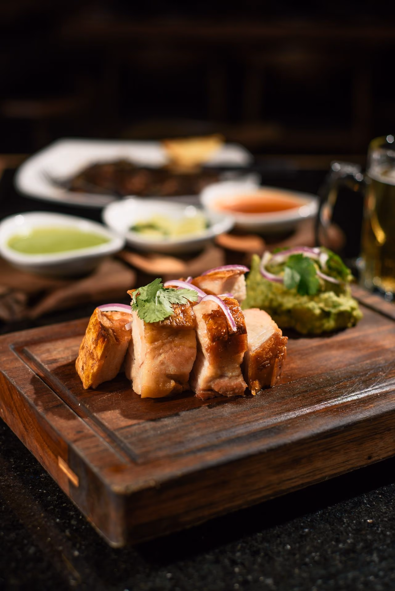 Pollo en tabla de madera con salsas y guacamole