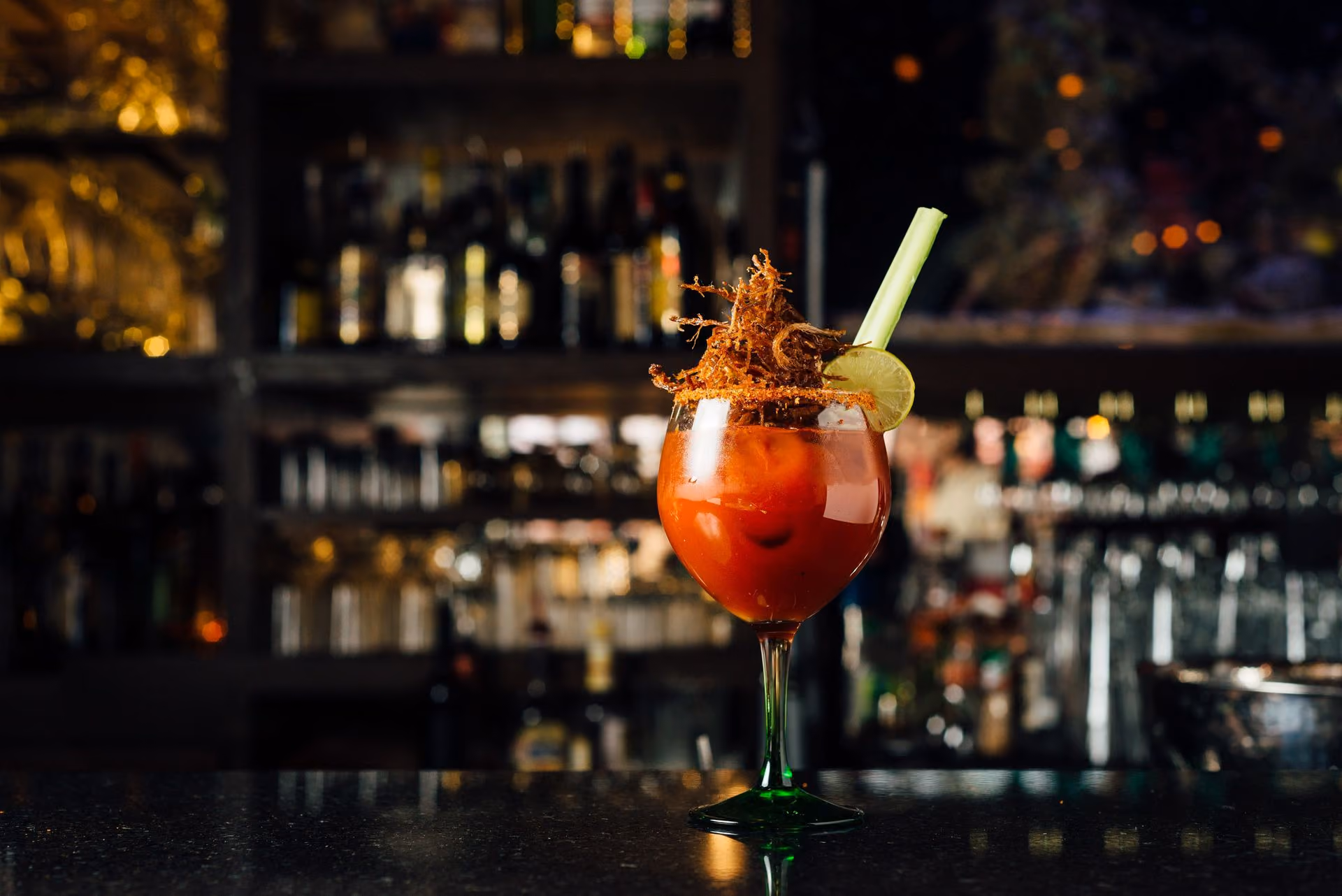 Coctel rojo frente a la contrabarra iluminada