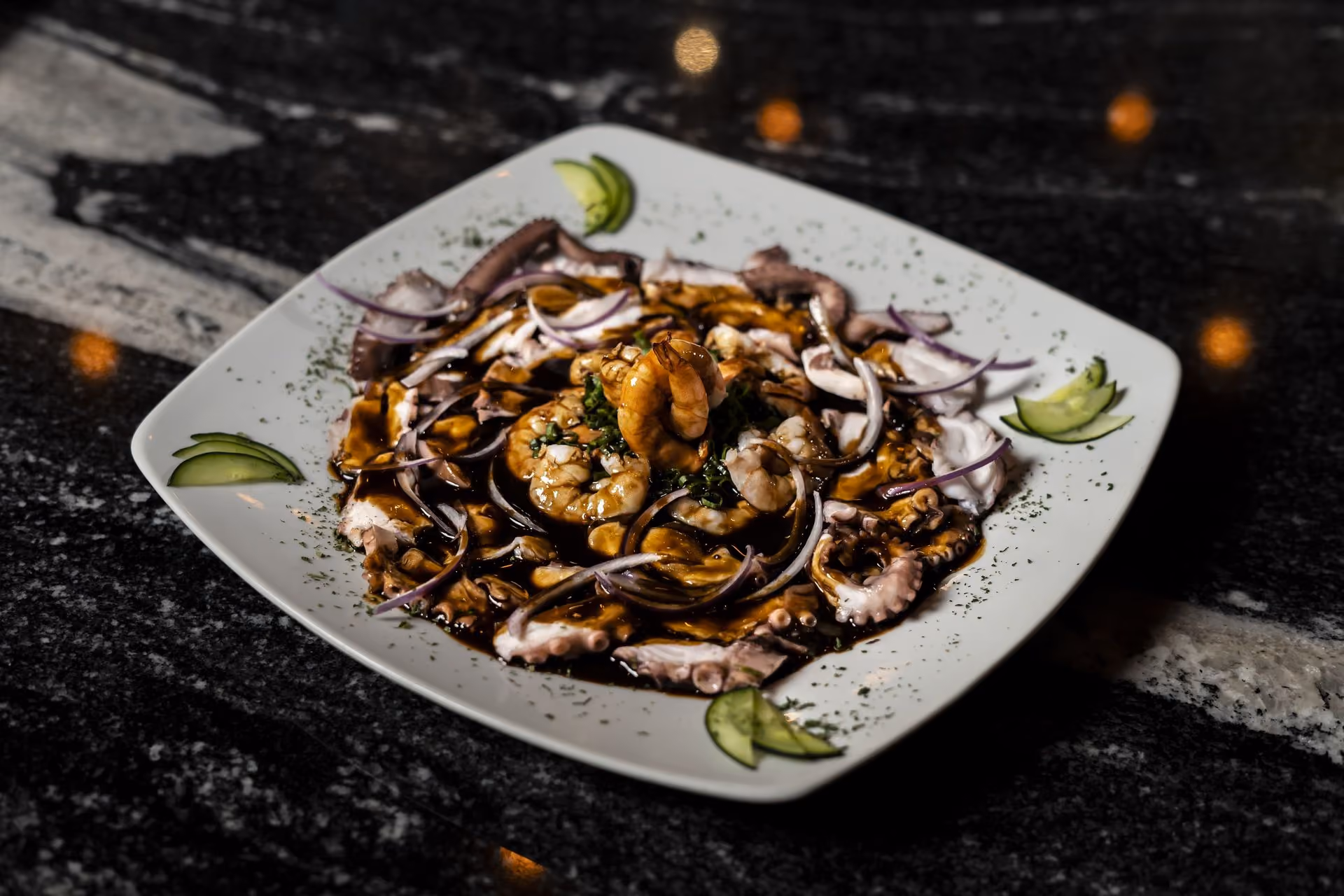 Pulpo en salsa oscura con cebolla morada y pepino