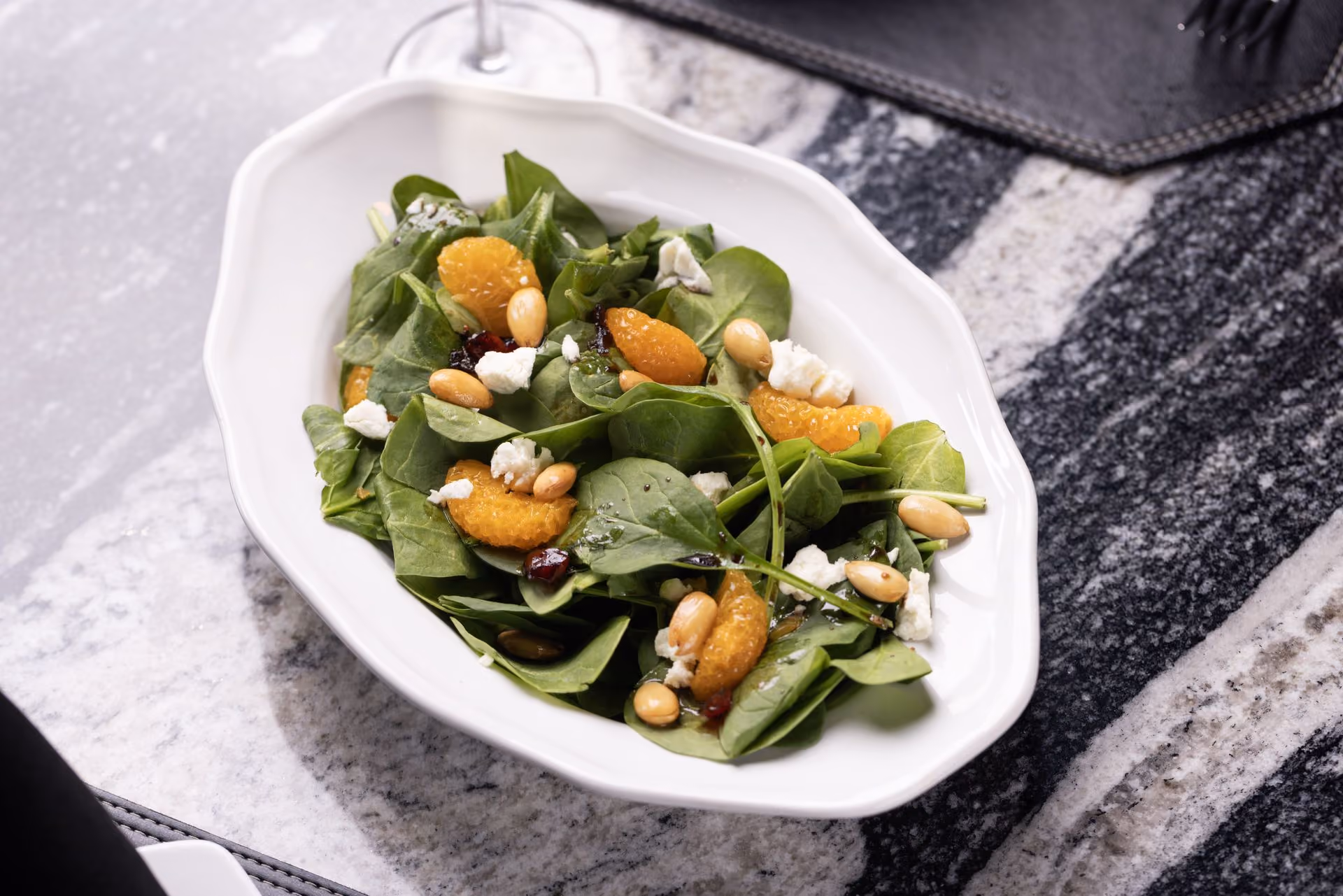 Ensalada de espinaca con gajos de mandarina, almendras y queso de cabra